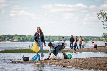 girls with trash on the beach. girls collect garbage on the beach. environmental concern