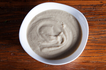 Nutrition concept - Healthy meals in White bowls over wooden background. Healthy food, Diet, Detox, Clean Eating or Vegetarian concept. Delicious soup made of mushrooms.