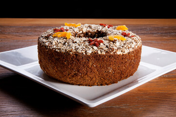 Traditional homemade Christmas cake. Holiday dessert with Damascus and dry goji berry on vintage wooden table background. Rustic style.