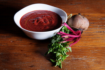 Nutrition concept - Healthy meals in White bowls over wooden background. Healthy food, Diet, Detox, Clean Eating or Vegetarian concept. Delicious soup made of beetroot.