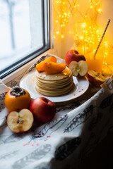 pancakes with fruit on a windowsill in winter