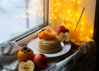 pancakes with fruit on a windowsill in winter