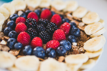 Cereals and fruits superbowl, healthy bowl breakfast with flakes, oat and fruits: strawberries, blueberries, banana, blackberries