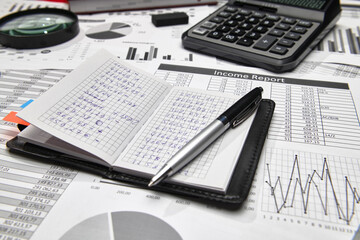 Top view of office employee's desk - work with financial reports, analysis and accounting, tables and graphs, various office items for bookkeeping