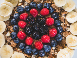 Cereals and fruits superbowl, healthy bowl breakfast with flakes, oat and fruits: strawberries, blueberries, banana, blackberries