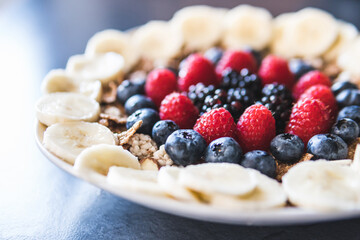 Cereals and fruits superbowl, healthy bowl breakfast with flakes, oat and fruits: raspberries, blueberries, banana, blackberries