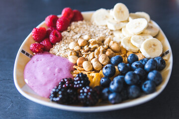 Cereals and fruits superbowl, healthy bowl breakfast with flakes, oat and fruits: raspberries, blueberries, banana, blackberries