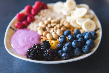 Cereals and fruits superbowl, healthy bowl breakfast with flakes, oat and fruits: raspberries, blueberries, banana, blackberries