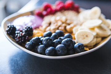 Cereals and fruits superbowl, healthy bowl breakfast with flakes, oat and fruits: raspberries, blueberries, banana, blackberries