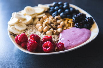 Cereals and fruits superbowl, healthy bowl breakfast with flakes, oat and fruits: raspberries, blueberries, banana, blackberries