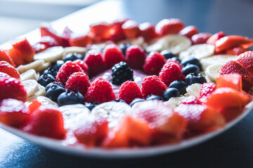 Cereals and fruits superbowl, healthy bowl breakfast with flakes, oat and fruits: strawberries,raspberries, blueberries, banana, blackberries