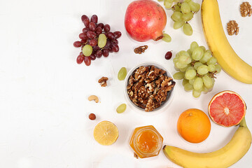 Healthy breakfast, food for children, granola, oranges, banana, pomegranate and grapes on a light table. The concept of healthy and natural food, lifestyle. selective focus, place for text
