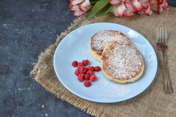 Breakfast. Two cheesecakes on a plate with raspberries. Milk products. Ricotta pancakes.