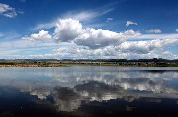 Lake scene in Montana with reflections of dynamic blue skies with clouds