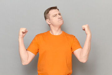 Portrait of proud and rebellious mature man raising clenched fists up