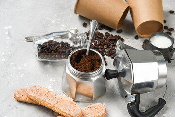 Ingredients for making moka coffee. Moka pot with coffee beans and ingredients on grey background. Coffee making concept. Flat Lay