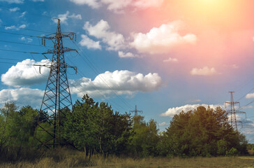 Obraz premium high-voltage power lines at clouds and pine forest.