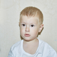 Fototapeta premium Little child in a white T-shirt on a light background