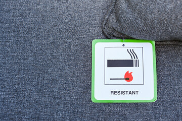 Label on the cushion of furniture showing the fabric has been treated to make it fire resistant