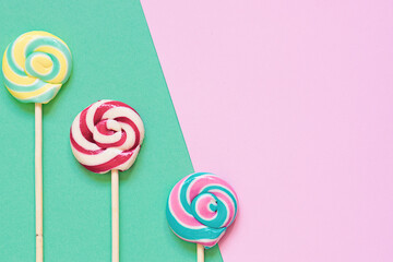 Colorful lollipops on two tone background top view, copy space for your design.