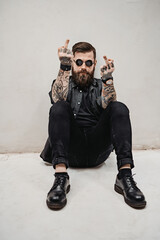 Brutal bearded guy with tattooed hands showing middle finger doing fuck you bad expression while...