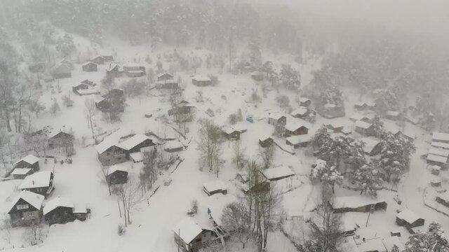 Snow-covered houses in the middle of mountains, Bolu Region. Aerial view of beautiful natural landscape in winter time