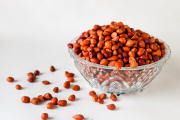 Peanuts on a glass bowl isolated in white background 