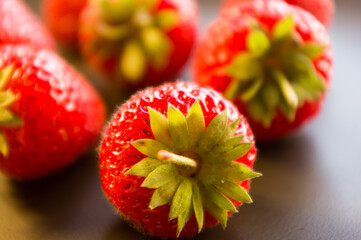 fresh ripe berries strawberries on black ceramic plate, close up