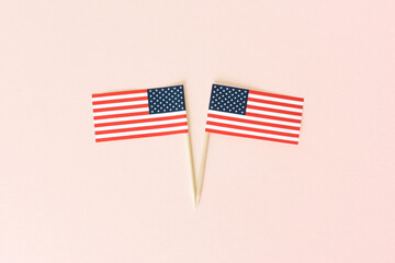 Two american flag toothpick on pink background, flat lay. Concept celebration usa independence day. 4th of july in America.
