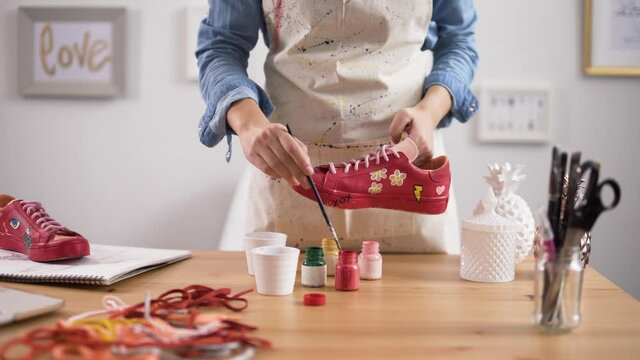 Entrepreneur customizing pair of sneakers in arts and crafts workshop
