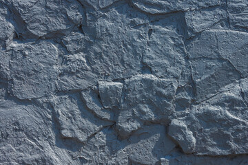 The texture of the wall is made of stone and painted gray