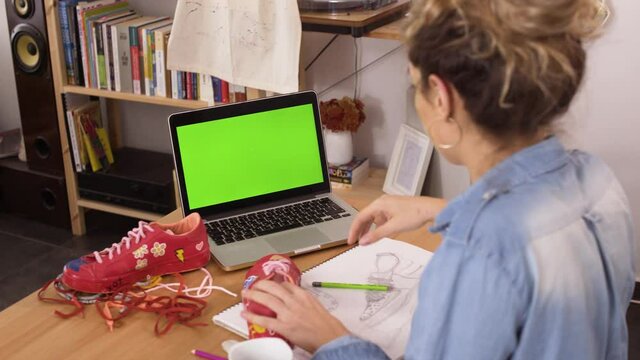 Young fashion designer working and doing online research on laptop