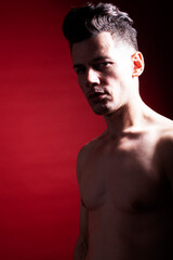 Fototapeta premium young fashion style man with naked torso dancing emotional posing on red background, lifestyle people concept