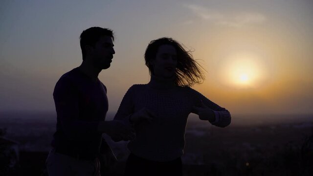 Happy dancers having fun during salsa practice outdoors at sunset