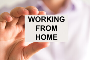 Businessman holding Working From Home message card