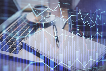 Double exposure of forex chart drawing and desktop with coffee and items on table background. Concept of financial market trading