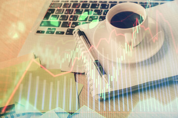 Double exposure of forex chart drawing and desktop with coffee and items on table background. Concept of financial market trading