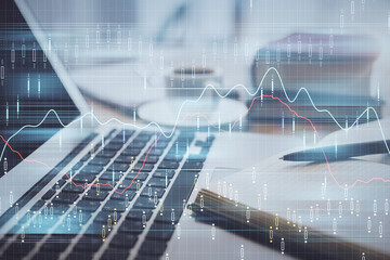 Double exposure of financial chart drawing and desktop with coffee and items on table background. Concept of forex market trading