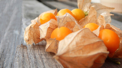 photograph of several cape gooseberries on a dark grey wooden background