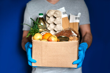 courier in gloves with a grocery box