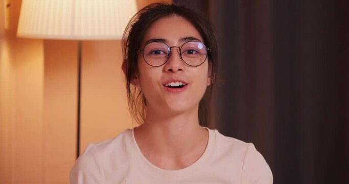 Young asian woman talking to camera at home. She recording video call to her friend or family in room.