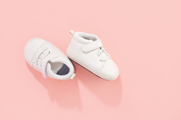 Baby shoes on pink background