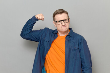 Portrait of proud and rebellious mature man raising clenched fist up