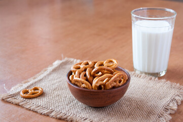 A glass of milk and a clay bowl of pretzels, Breakfast on the table