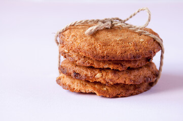 Oatmeal cookies tied with string on a pink background