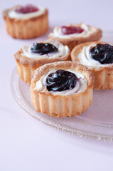 Cookies with jam on a transparent plate on a pink background, space for text