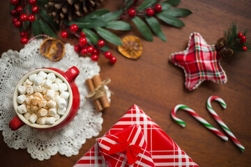 Hot chocolate surrounded by christmas items and tree