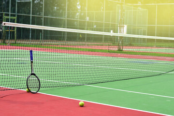 Closeup of Tennis Racket and balls on Tennis Courts in the outdoors.