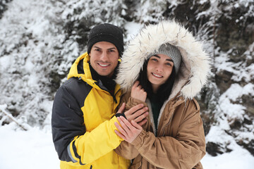 Fototapeta na wymiar Lovely couple outdoors on snowy day. Winter vacation