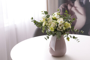 Vase with beautiful bouquet on white table indoors. Stylish interior element